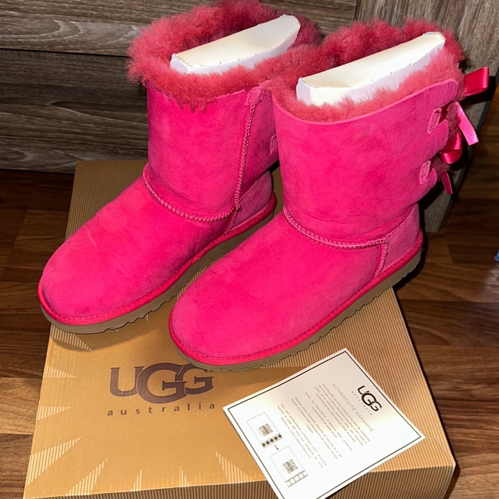 Big kids pink Bailey bow uggs.